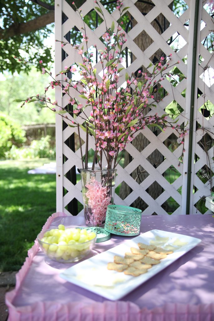 Pink flowers in glass vase on food table at fairy birthday party